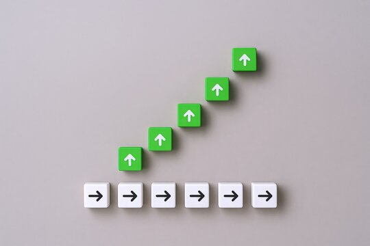 Ascending Green Arrow Blocks Representing Growth and Progress, Positioned Above Horizontal White Arrow Blocks on Grey Background - Powered by Adobe