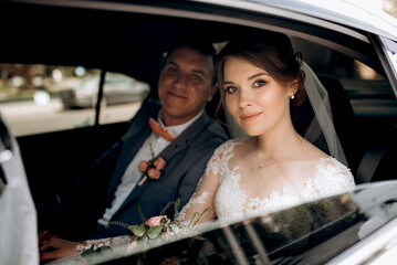bride and groom with a black car
