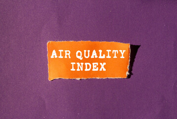 Air Quality Index message written on ripped torn orange paper piece on purple background....