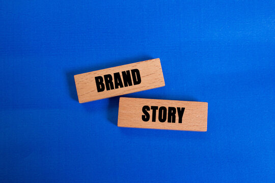 Brand story message written on wooden blocks on blue background. Conceptual brand story symbol. Copy space.