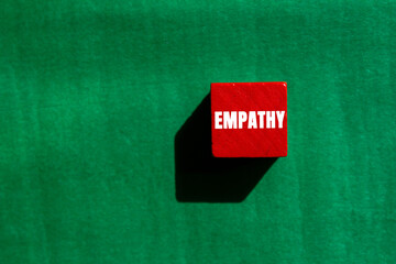 Empathy message written on red wooden cube on green background. Conceptual Empathy symbol. Copy space.