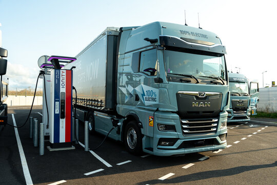 Electric truck plugged into a highway charging station symbolizing renewable energy use and sustainable transport with modern battery powered freight solutions. France &ndash; August 6, 2025