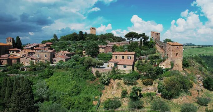 Panoramic aerial view of Monticchiello Village surrounded by lush greenery in Tuscany, Italy