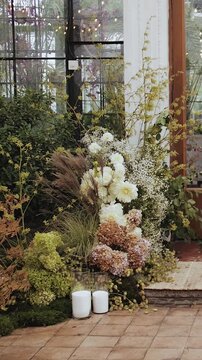 Floral arrangement, wedding or event decor. A beautiful restaurant entrance decorated with bright flowers and greenery creates a cozy atmosphere for everyone. Vertical video