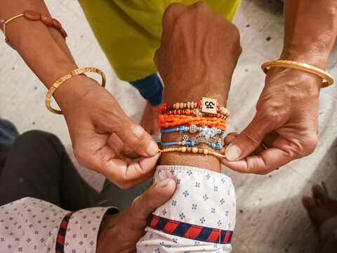 Raksha Bandhan Hindu religious festival where a Sister is tying the sacred Rakhi thread on her brother's right hand in Mysore, India.