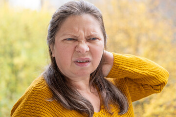 skeptical woman narrows eyes, expression filled with doubt in natural setting, raised eyebrow and...