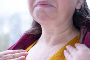mature woman's neck, natural wrinkles, Health check or awareness gesture focusing on throat thyroid...