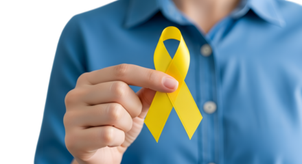 Photo of hand holding yellow ribbon for supporting childhood cancer awareness campaign isolated on transparent background