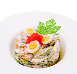 Fresh creamy salad topped with quail eggs, red caviar, and decorative garnish