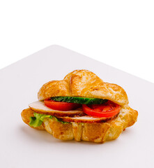 Fresh croissant sandwich featuring turkey, tomatoes, and lettuce