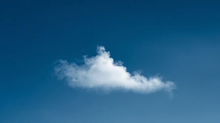 A single fluffy white cloud floats against a clear, deep blue sky, showcasing a serene and minimalistic natural scene.
