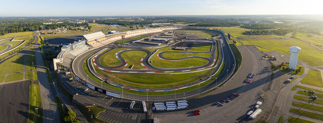 Concord, United States - 28 July 2025: Aerial view of Charlotte Motor Speedway, where the vibrant green infield contrasts sharply with the grey asphalt track.