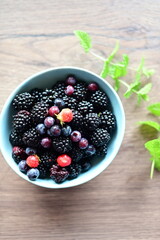 Top view of a bowl filled with fresh blackberries. The vibrant dark purple berries create a visually appealing and healthy snack option, perfect for summer, natural food, and fruit themes.