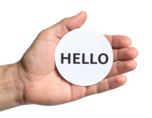 A hand holds a round card with the word "HELLO" printed in bold letters.