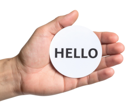 A hand holds a round card with the word "HELLO" printed in bold letters.