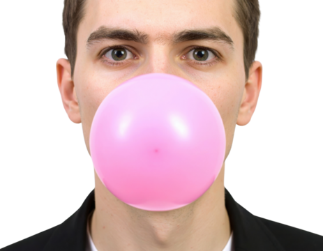 A young man blows a large pink bubble with bubblegum, showcasing a playful expression against a solid black background.