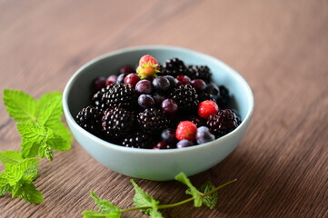 Top view of a bowl filled with fresh blackberries. The vibrant dark purple berries create a visually appealing and healthy snack option, perfect for summer, natural food, and fruit themes.