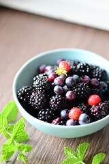 Top view of a bowl filled with fresh blackberries. The vibrant dark purple berries create a visually appealing and healthy snack option, perfect for summer, natural food, and fruit themes.
