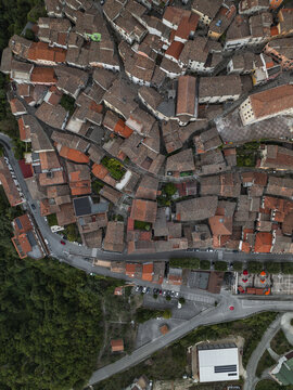 Aerial view of a historic Italian town with terracotta rooftops cascading down the hillside, a vibrant contrast to the lush greenery below, Morcone, Benevento, Campania, Italy.