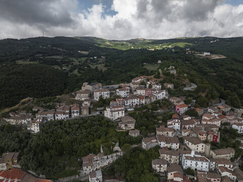 Aerial view of a charming Italian village nestled amongst rolling hills, with terracotta roofs contrasting against the lush green landscape, Morcone, Benevento, Campania, Italy.
