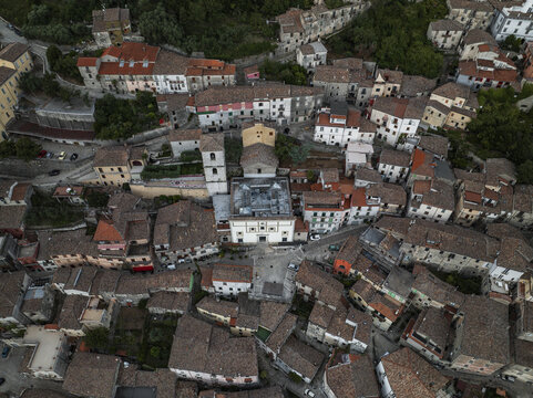 Aerial view of sun-kissed terracotta roofs and white stone buildings clustered around the central church in the ancient town, Morcone, Benevento, Campania, Italy.