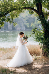 bride blonde girl with a bouquet in the forest