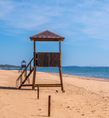 Lifeguard towers on an empty sandy beach in summer.
