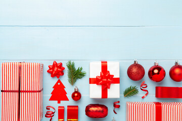 Handmade wrapped christmas gift boxes with stuff on wooden background, top view