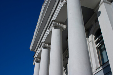 Detail of the facade of a building with columns and blue sky