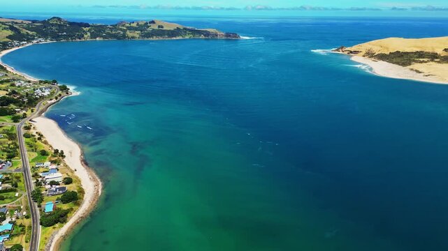Aerial view of Omapere Beach's turquoise waters meeting the sandy shore, contrasting with lush green hills, Omapere, Northland Region, New Zealand.