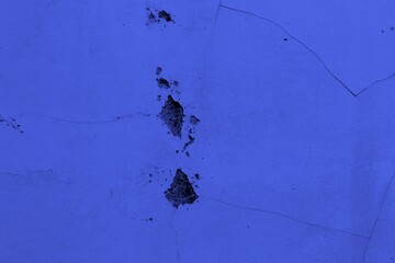 Close-up view of a blue textured wall showing rough patterns and intricate shadow details, offering a visually appealing background texture for versatile creative uses.