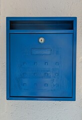 Viejo buzón de correos de metal pintado de color azul en la fachada de una casa	