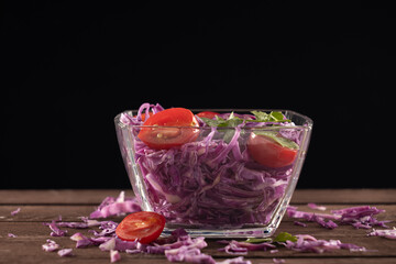 Glass bowl filled with red cabbage and tomatoes