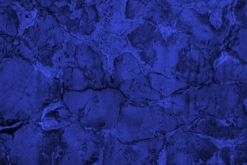 Close-up view of a blue textured wall showing rough patterns and intricate shadow details, offering...