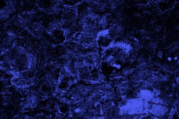 Close-up view of a blue textured wall showing rough patterns and intricate shadow details, offering a visually appealing background texture for versatile creative uses.