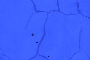 Close-up view of a blue textured wall showing rough patterns and intricate shadow details, offering a visually appealing background texture for versatile creative uses.