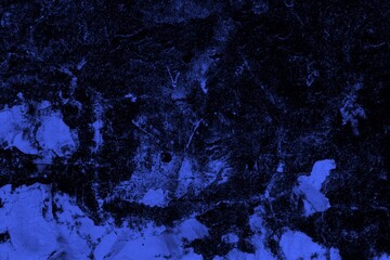 Close-up view of a blue textured wall showing rough patterns and intricate shadow details, offering...