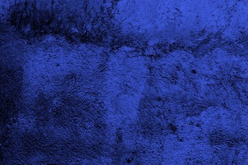 Close-up view of a blue textured wall showing rough patterns and intricate shadow details, offering...