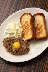 Classic Steak Tartare with Quail Egg Yolk, Toast, and Creamy Sauce