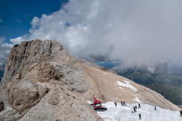 Panorama der Marmolata mit Besuchern und roter Pistenraupe