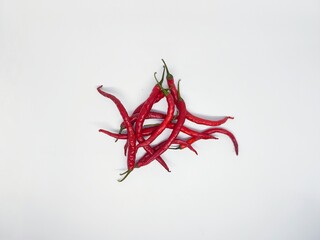 A pile of vibrant red chili peppers isolated on a clean white background. These fresh, spicy ingredients are perfect for adding flavor to any dish.