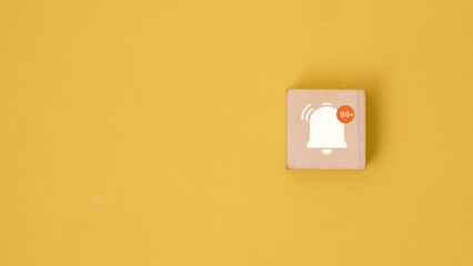 Notification Alert Concept with Bell Icon and 99 Plus Badge on Wooden Block