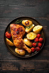 Oven roasted chicken leg quarter with potatoes, tomatoes