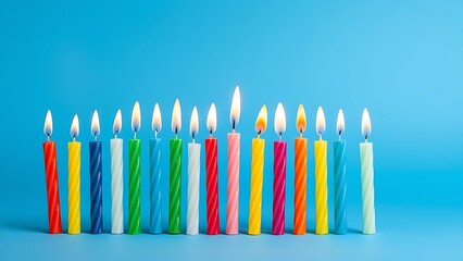 Row of colorful birthday candles arranged neatly on a vibrant blue surface.