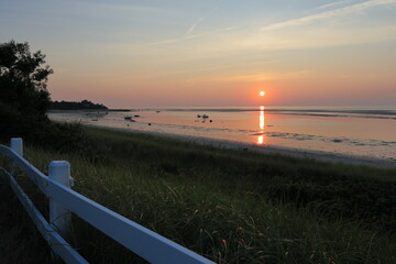 Stunning orange and pink skies from the sun setting over Cape Cod Bay