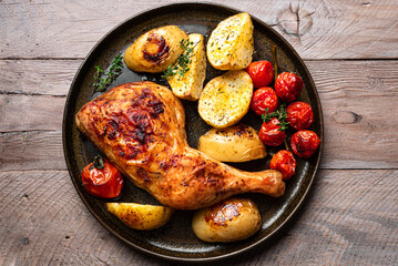 Oven roasted chicken leg quarter with potatoes, tomatoes