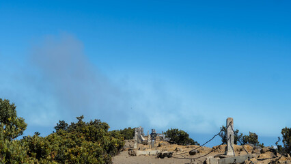 Military Tank Firing Main Gun: Dust Cloud Erupts on Arid Training Ground Under Clear Blue Sky