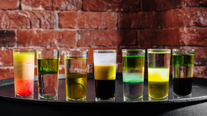 Colorful variety of layered shots displayed against a brick wall