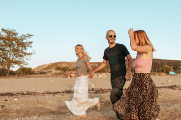 Happy couple running on the beach at sunset in Potos, Thassos