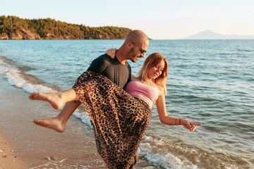 Couple playing in shallow water at golden hour in Potos, Thassos